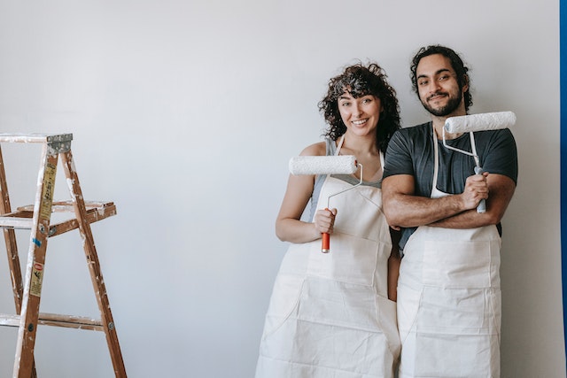 woman and man holding paint brushes